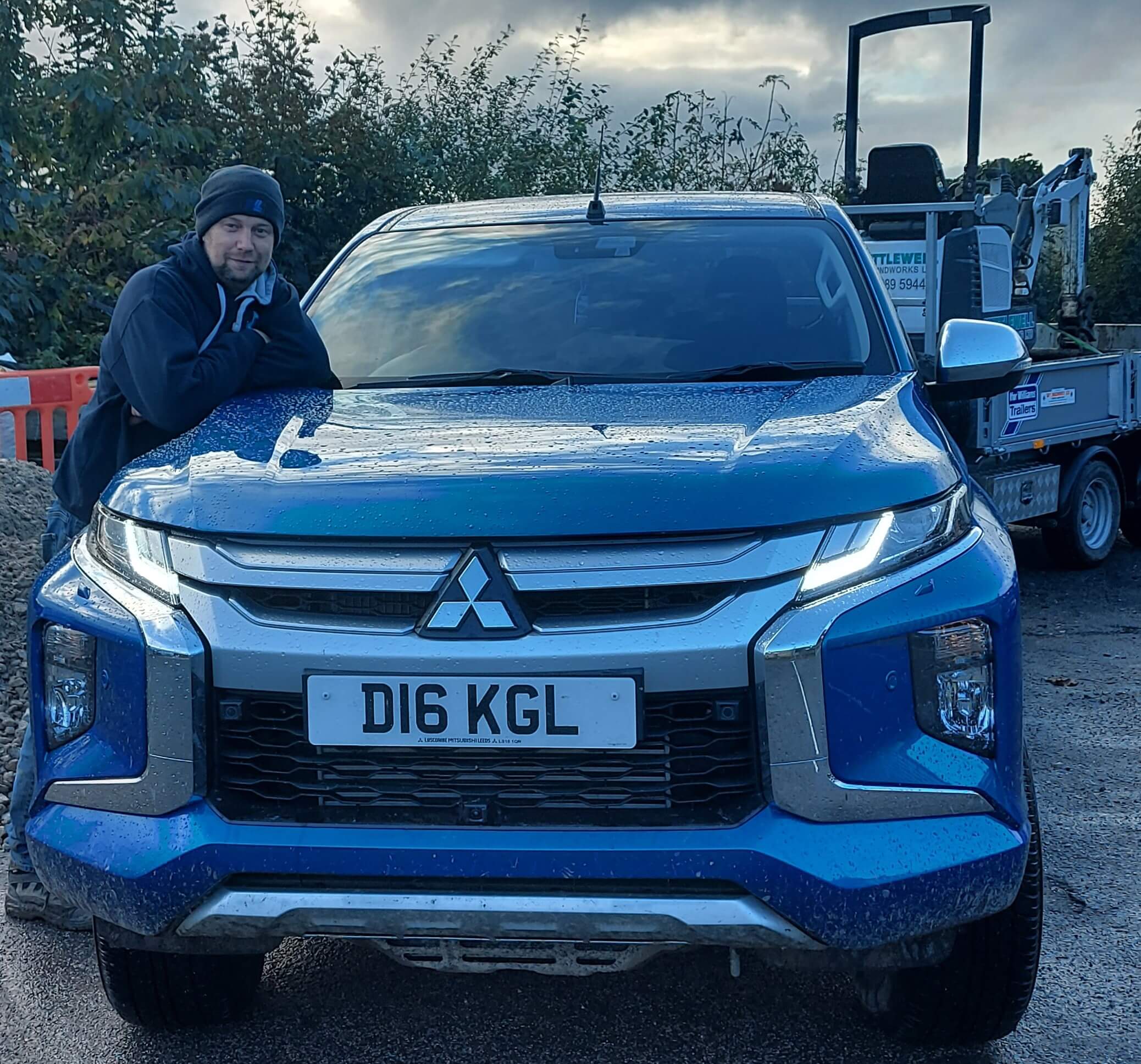 Richard Kettlewell stood with Mitsubishi L200 and a micro digger on a trailer