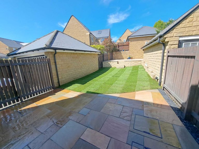 Rippon buff sandstone patios with fresh natural turf lawn