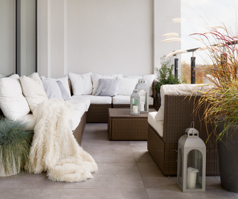Cosy autumn garden with furniture, blankets and cushions for warmth